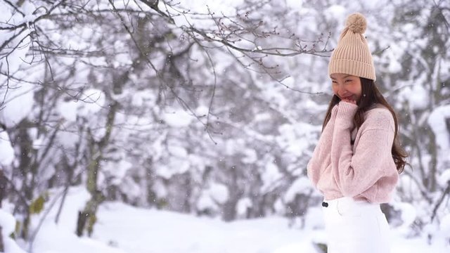 Young asian woman smile and happy in snow winter season