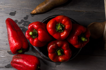 STILL LIFE OF RED PEPPERS ON A RUSTIC WOODEN TABLE