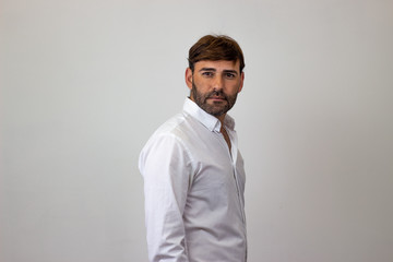 Fashion portrait of handsome young man with brown hair in love, their back facing the camera and looking at the camera. Isolated on white background.