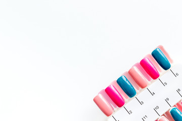 cosmetics for manicure with palette for spring nail design in nail bar on white background top view copyspace