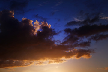 Golden sunlight and fluffy orange cloud on the blue sky an evening time