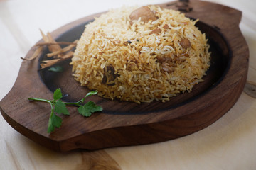 Indian traditional dish with rice and coriander leaf on wooden tray