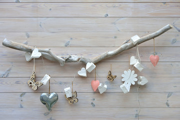 Different ornaments hung on a stick on a white background/