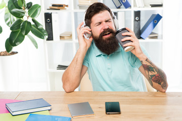 Regular office day. Man bearded guy headphones sit office listen music sing song. Worker with...