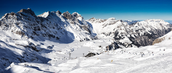 Beautiful winter landscape with Swiss Alps. Skiers skiing in famous Engelgerg - Titlis ski resort, Switzerland, Europe