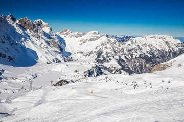 Fototapeta na wymiar Beautiful winter landscape with Swiss Alps. Skiers skiing in famous Engelgerg - Titlis ski resort, Switzerland, Europe