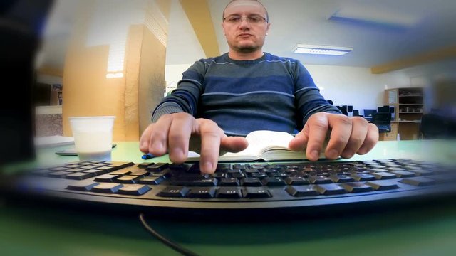 Software engineer is developing program coding on his laptop computer and drinking coffee. View from espionage online web camera