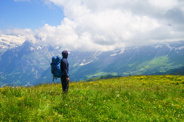 Hiker traveling in Alps. Alpine peaks landskape background. Jungfrau, Bernese highland. Sport, tourism and hiking concept.