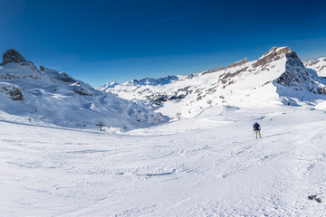 Beautiful winter landscape with Swiss Alps. Skiers skiing in famous Engelgerg - Titlis ski resort, Switzerland, Europe