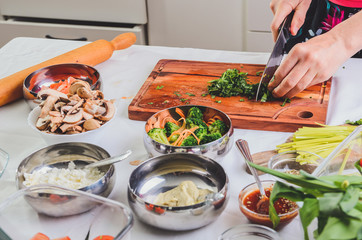 Female hands chopping broccoli, preparing ingredients for a delicious meal