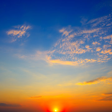 Scenic sunset on background bright blue sky and clouds