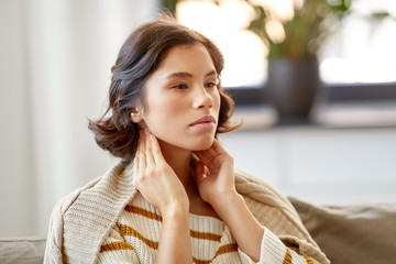 cold and health problem concept - sick woman touching her lymph nodes at home