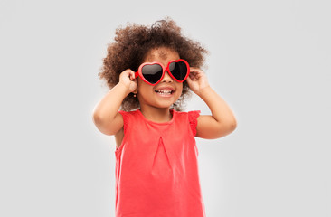childhood, valentine's day and summer concept - happy little african american girl in heart shaped...