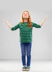 childhood, faith and thanks concept - grateful smiling red haired girl in green striped shirt and...