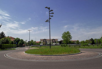 round of a little-used peripheral road with a flowerbed with poppies in the center