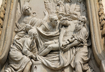 Fototapeta na wymiar Cristo deposto nel sepolcro; particolare del coronamento del portale centale della chiesa di Santa Maria della Passione; Milano