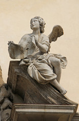 Fototapeta na wymiar Angelo col cartiglio della Croce (INRI); portale centrale della chiesa di Santa Maria della Passione; Milano