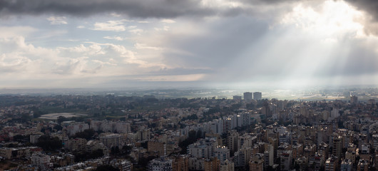Obraz premium Aerial panoramic view of a residential neighborhood in a city during a cloudy sunrise. Taken in Netanya, Center District, Israel.