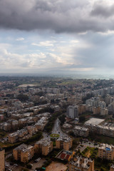 Aerial view of a residential neighborhood in a city during a cloudy sunrise. Taken in Netanya, Center District, Israel.