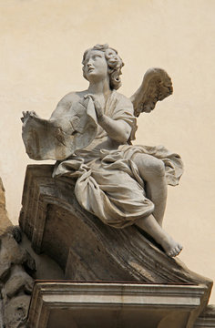 Angelo col cartiglio della Croce (INRI); portale centrale della chiesa di Santa Maria della Passione; Milano
