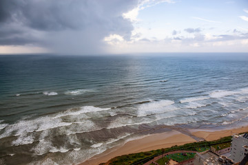 Beautiful aerial view of a sandy beach during a cloudy sunrise. Taken in Netanya, Center District, Israel.