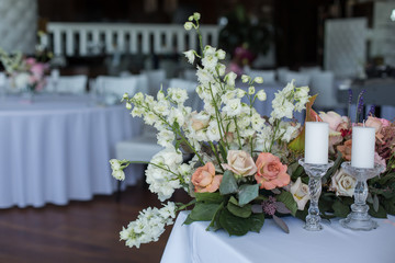 Event white restaurant table served and decorated with delicate fresh flowers