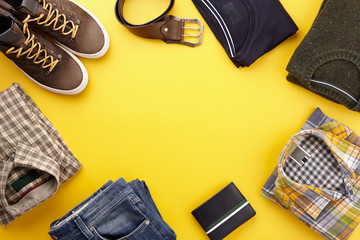 Mens casual clothing outfits and accessories flat lay on yellow background, top view