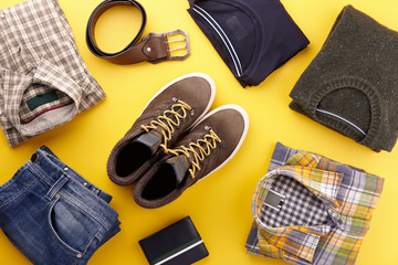 Mens casual clothing outfits and accessories flat lay on yellow background, top view