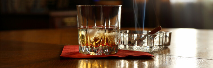 Panorama still life with a glass of whiskey and a cigarette