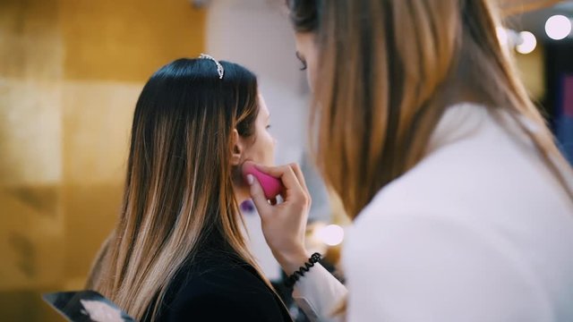 visagist doing make-up with professional cosmetics and brushes