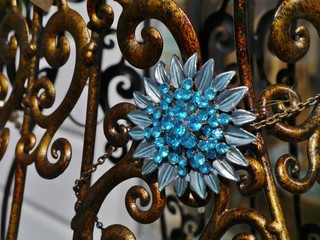 Blaue Brosche am Bronzeständer