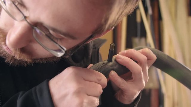 Man Checking Bicycle Inner Tube for Air Leaks