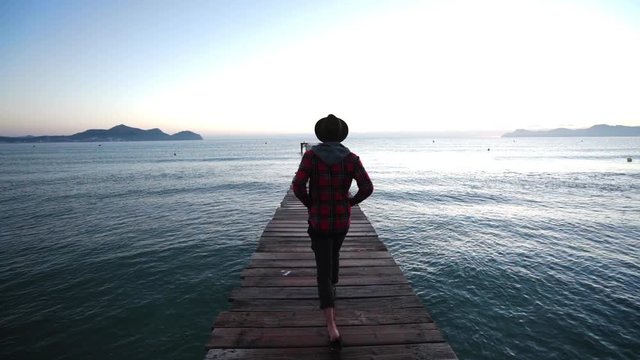 Guy walks down a bridgte to the Sea of Mallorca