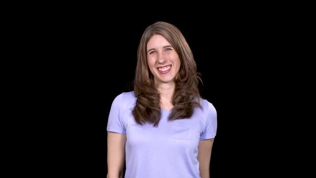 Brunette woman gives the camera a double thumbs up while standing on a black studio background