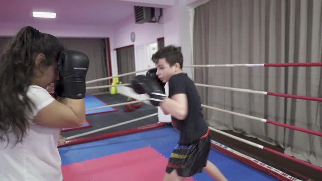 Boy and girl kickbox sparring