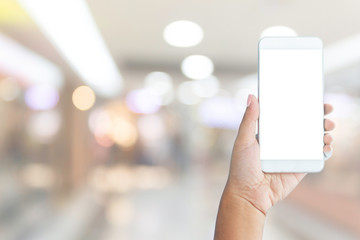 hand hold smart phone and shopping mall blurry background