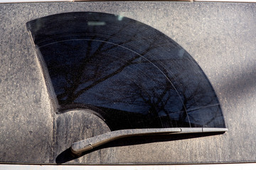 windshield wiper dirty car covered with a layer of dried dirt on the back window.