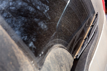 windshield a dirty car wiper, close up of a car wiper in the dust.