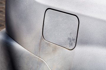gas tank cover, gray dirty car, close-up of the door on the rear fender of the car covered with...