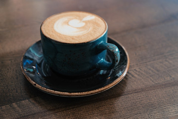 Side view of Coffee cup with perfect latte art on foam on tabletop