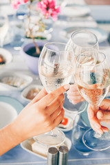 Three glasses of wine cheering at the local greek restaurant. Healthy vegetarian snacks. Local mediterranean cuisine. Friendly dinner or lunch