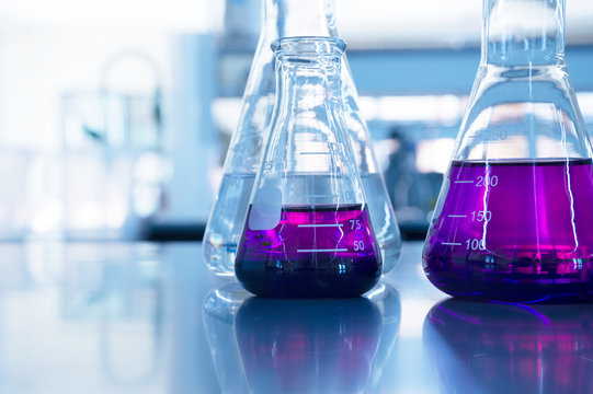 chemical purple water solution in glass flask at education science laboratory background