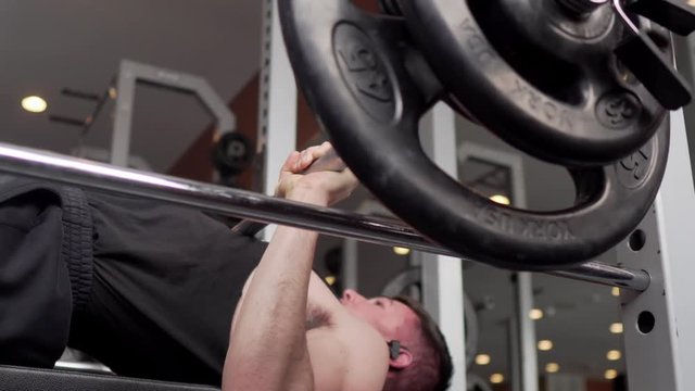 Person lifting weights and exercising in the gym. 24 fps. Shot in 4k exported in 1080p. Shallow depth of field.