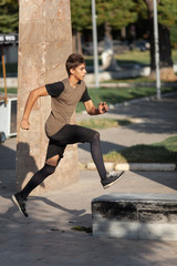 A teenage boy goes in for parkour in a city park