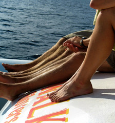 Legs of young people relaxing of a boat