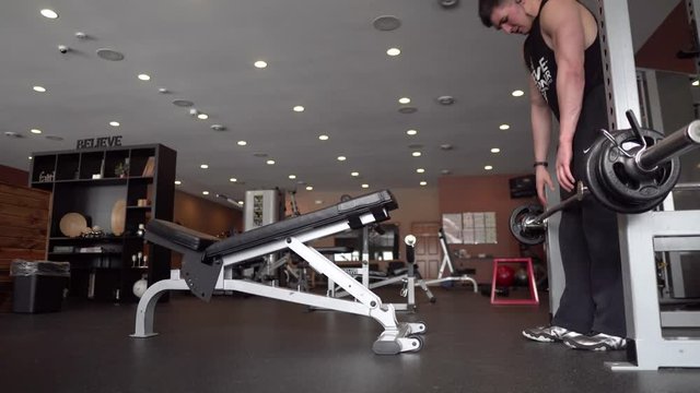 Person lifting weights and exercising in the gym. 4K. 24 fps. Shallow depth of field.