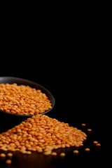 Red lentils on black background