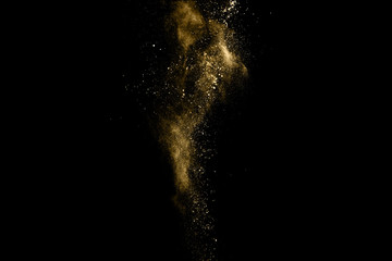 Golden powder explosion on black background. Freeze motion.