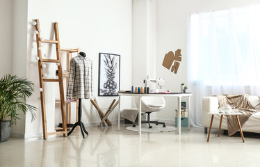 Stylish workplace of tailor with sewing machine in workshop