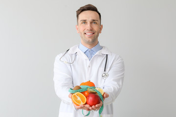 Portrait of male nutritionist on light background